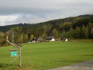 a large green field with a sign in the grass at Steinerhof in Sankt Georgen ob Murau