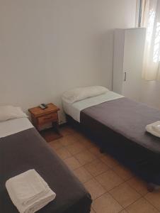 a room with two beds and a table with a night stand at Hotel Cielo Cuyano in San Juan