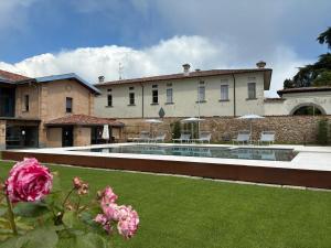 a large house with a swimming pool in a yard at Elegant suite with porch and shared pool in Adro
