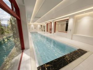a swimming pool in a house with a large window at LiVEMAX Golf Club Tochigi in Kanuma