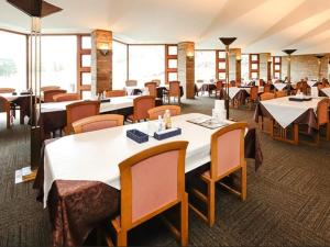 a dining room with tables and chairs and windows at LiVEMAX Golf Club Tochigi in Kanuma