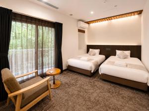 a bedroom with two beds and a chair and a window at LiVEMAX Golf Club Tochigi in Kanuma +19 photos