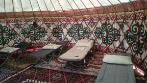 a room with tables and chairs in a yurt at Актан in Chong-Kyzylsu