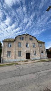 a large brick building on the side of a street at Smilšu ielas Hostelis in Valmiera