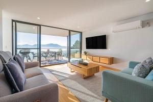 a living room with two couches and a tv at Rosetta Vista - Architectural Haven with River Views in Berriedale