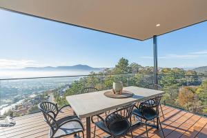 a table and chairs on a balcony with a view at Rosetta Vista - Architectural Haven with River Views in Berriedale