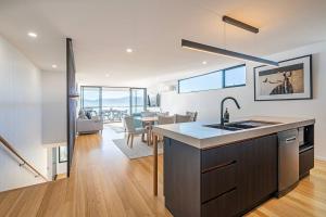 a kitchen and dining room with a view of the ocean at Rosetta Vista - Architectural Haven with River Views in Berriedale