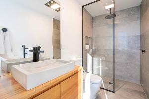 a bathroom with a white tub and a toilet at Rosetta Vista - Architectural Haven with River Views in Berriedale +29 photos