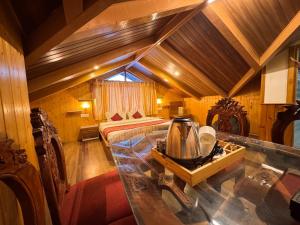 a bedroom with a bed and a table in a room at Hotel The Red Apple in Manāli +11 photos