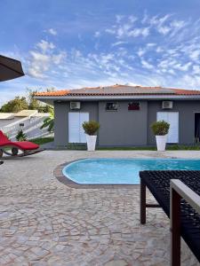 a house with a swimming pool in a yard at Suítes Brotas in Brotas