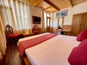 a bedroom with a large bed in a room at Hotel The Red Apple in Manāli