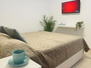 a bed with a blue coffee cup on a table at MBZ Apartments #1 - 1 Bedroom, Private Parking & Air Conditioning in Roman