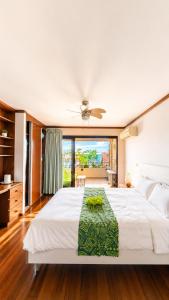 a bedroom with a large white bed and a large window at Blue Lagoon - Studio avec accès piscine in Papeete