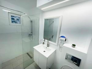 a white bathroom with a sink and a shower at MBZ Apartments #1 - 1 Bedroom, Private Parking & Air Conditioning in Roman +20 photos