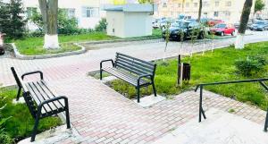 a park with two benches on a brick sidewalk at MBZ Apartments #1 - 1 Bedroom, Private Parking & Air Conditioning in Roman