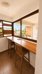 a dining room with a wooden table and chairs at Blue Lagoon - Studio avec accès piscine in Papeete