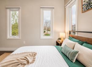 ein Schlafzimmer mit zwei Fenstern und einem Bett in der Unterkunft Spacious 3BDR Home Central Markham in Markham