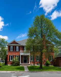 ein Backsteinhaus mit einem Baum davor in der Unterkunft Spacious 3BDR Home Central Markham in Markham