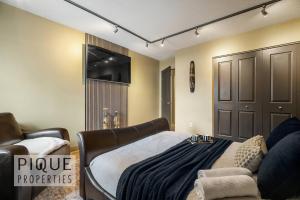 a living room with a bed and a couch at Urban Oasis - with 16ft Swim Spa - Heated Hot Tub & Pool in Edmonton +62 photos