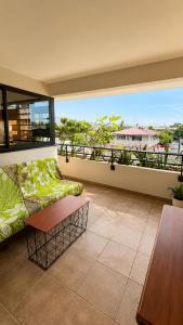 a living room with a couch and a table on a balcony at Blue Lagoon - Studio avec accès piscine in Papeete