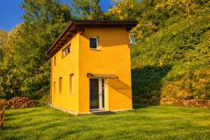 a small yellow house in a field of grass at Nazem Holiday in Comunanza