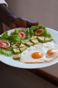 a plate of food with eggs and vegetables on it at Hotel mango tree nearest Adam's peak in Nallathanniya