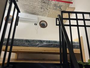 a bed in a room next to a staircase at A corner by the sea in Ashdod