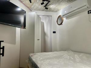 a small bedroom with a bed and a mirror at A corner by the sea in Ashdod