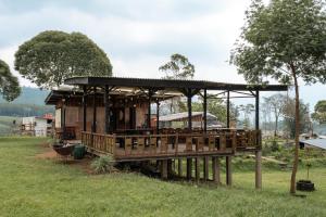 a building with a deck in a field at WWS Cabin By ARBA in Palayangan