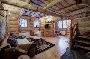 a living room of a log cabin with wooden walls at Góralski Domek z kominkiem - Highlander Wooden House in Murzasichle