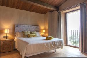 a bedroom with a large bed and a large window at La Masoveria de Mateus in Sagás