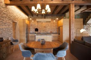 a kitchen with a table and chairs in a room at La Masoveria de Mateus in Sagás