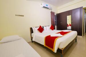 a bedroom with a large bed with red pillows at Hotel Shree Laksha Residency Madurai in Madurai +101 photos