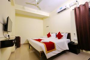 a bedroom with a large bed with red pillows at Hotel Shree Laksha Residency Madurai in Madurai