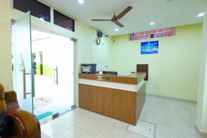 a lobby with a bar with a ceiling fan at Hotel Shree Laksha Residency Madurai in Madurai