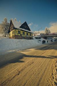 un edificio al lado de una carretera cubierta de nieve en Pensjonat Stokłos en Duszniki Zdrój