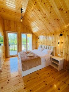 a bedroom with a large bed in a wooden room at Loreta's Canyon Farmhouse in Martvili