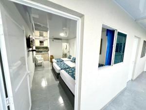 a living room with two beds and a window at Limsor Town Apartaestudios in San Andrés