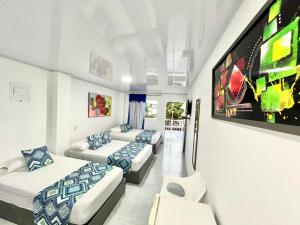 a room with three beds and a flat screen tv at Limsor Town Apartaestudios in San Andrés