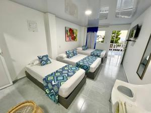 a bedroom with two beds and a couch at Limsor Town Apartaestudios in San Andrés