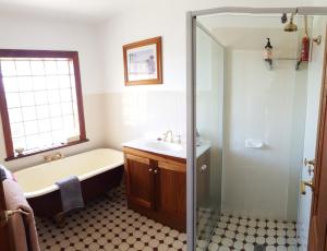 a bathroom with a tub and a sink and a shower at Maria's at Swansea in Swansea