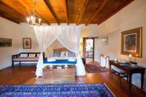 a bedroom with a bed with a canopy at Tulbagh Country Guest House - Cape Dutch Quarters in Tulbagh +103 photos