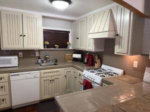 a kitchen with white cabinets and a stove top oven at Near the Slopes - Big Bear Mountain getaway in Big Bear Lake