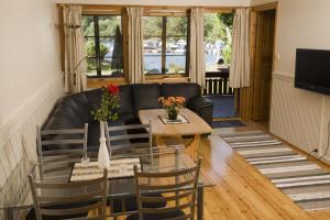 a living room with a black leather couch and a table at Mones Feriesenter in Mandal