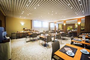 a dining room with tables and chairs in a restaurant at Hotel Roma in Aosta