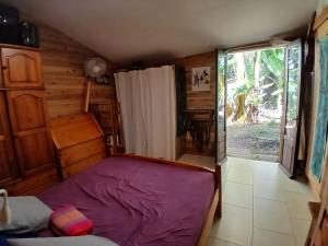 a bedroom with a purple bed and a window at maison entière in Saint-Pierre