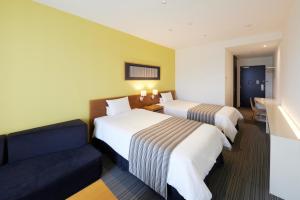 a hotel room with two beds and a couch at Hotel Rotterdam Huis Ten Bosch in Sasebo