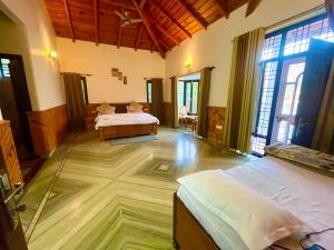 a bedroom with two beds in a room with windows at Voyager stone cottage in Bhīm Tāl