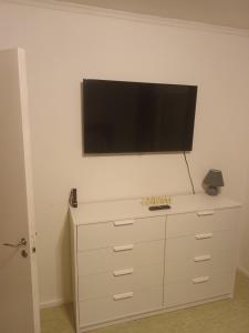 a flat screen tv on top of a dresser at Peaceful Comfort in Suni