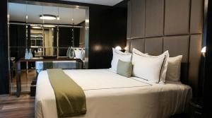 ein Schlafzimmer mit einem großen Bett mit weißen Laken und Kissen in der Unterkunft Hippodrome Hotel in Mexiko-Stadt + 40 Fotos